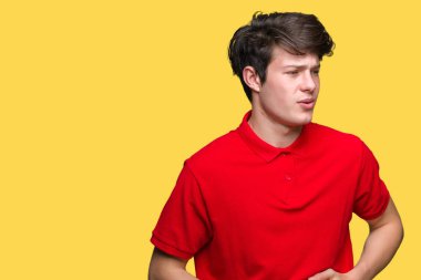 Üzerinde kırmızı t-shirt giyen genç yakışıklı adam izole mide üzerinde el ile arka plan çünkü hazımsızlık, ağrılı hastalık hasta hissediyor. Ağrısı kavramı.