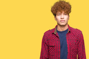 Yüzünde ciddi bir ifade ile ceket afro saçlı genç yakışıklı öğrenci adam. Basit ve doğal kameraya bakıyor.