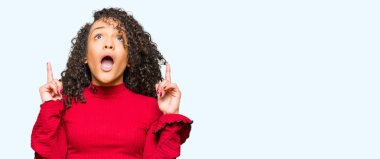 Kıvırcık saçlı Genç güzel kadın hayrete ve yukarıya bakıp parmakları ile işaret şaşırttı ve silah kaldırdı.