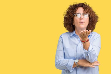 Güzel orta ager üst düzey businees kadın bir öpücük el ile güzel ve seksi olmak hava üfleme kamera bakarak izole arka plan üzerinde gözlük takıyorum. Aşk ifade.