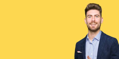 Genç yakışıklı bussines gösteren palm el ve yukarıya, mutlu ve neşeli gülümseyen baş parmakları Tamam jest yapıyor adamım