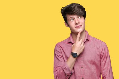 Genç yakışıklı iş adamı çene düşünme hakkında soru, dalgın ifade üzerine el ile izole arka plan üzerinde. Düşünceli yüzüyle gülümsüyor. Şüphe kavramı.