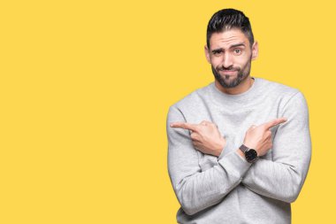 Genç yakışıklı adam giyen kazak izole üzerinde arka plan için her iki parmak, farklı yönde ile katılmıyorum işaretleme