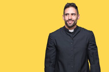 Genç Hıristiyan rahip görünümlü yan ve dik dik bakma uzağa düşünce gülümseyen izole arka plan üzerinde.