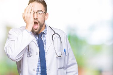 Yakışıklı genç doktor adam izole arka yüz ve sürpriz duygu kendinden emin gülümseme ile el ile bir göz kapsayan.