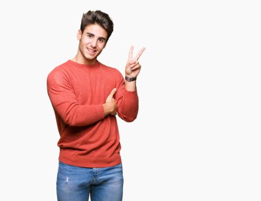 Mutlu yüz zafer işareti yaparken kameraya göz kırpıyor ile gülümseyen izole arka plan üzerinde genç yakışıklı adam. İki numaralı.