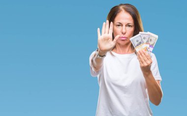 Dolar demet izole arka plan üzerinde açık eliyle dur işareti ile ciddi ve kendine güvenen ifade, savunma jest yapıyor tutan orta yaş İspanyol kadın
