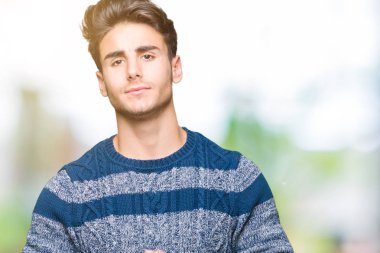 Genç yakışıklı adam arka plan eller birlikte izole ve rahat ve neşeli gülümseyen parmak çarpı işareti. Başarı ve iyimser