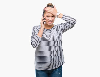 Genç güzel beyaz kadın baş, el ile vurguladı izole arka plan üzerinde Smartphone'da söz şok utanç ve sürpriz suratla, öfkeli ve sinirli. Korku ve hata için üzgün.