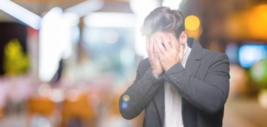 Yüzünü elleriyle ağlayarak süre kapsayan üzgün ifade ile izole arka plan üzerinde kış palto giyiyor zarif delikanlı. Depresyon kavramı.