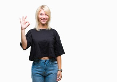 Gülümseyen izole arka plan üzerinde genç güzel sarışın kadın el ve parmaklar ok işaretiyle yapıyor olumlu. Başarılı ifade.