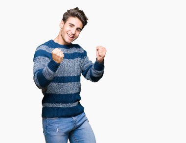 Soyutlanmış, mutlu ve heyecanlı genç bir adam kollarını kaldırmış, gülümseyen ve başarı için çığlık atan kazanan bir jest yapıyor. Kutlama konsepti.