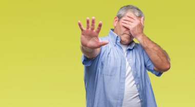 Yakışıklı kıdemli adam elleriyle gözlerini kapsayan izole arka plan üzerinde ve stop jest ile acı ve korku ifadesi. Utandım ve negatif kavramı.