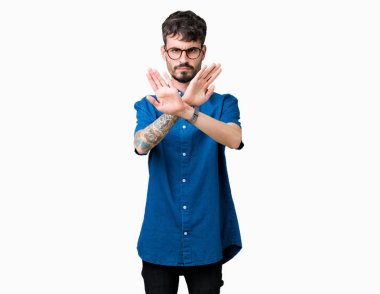 Yakışıklı delikanlı izole arka plan ret ifade geçiş silah ve avuç içi eksi işareti, kızgın surat yapıyor üzerinde gözlük