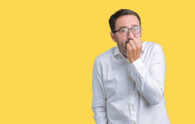 Stresli ve gergin elle çivi ısırma ağzına bakarak izole arka plan üzerinde gözlük takan yakışıklı orta yaş zarif üst düzey iş adamı. Anksiyete sorunu.