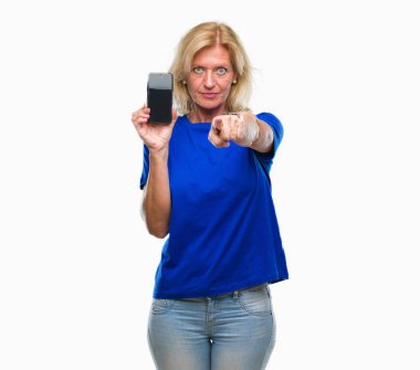 Orta yaş sarışın kadın gösteren boş ekran smartphone izole arka kamera ve size parmak ile işaret üzerine, el işareti, pozitif ve kendinden emin bir jest ön