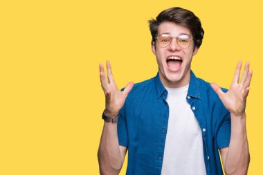 Üzerinde gözlük takan genç yakışıklı adam deli kutluyor arka plan izole ve silah ile başarı için yükseltilmiş ve açık gözleri heyecanlı çığlık hayrete düşürdü. Kazanan kavramı