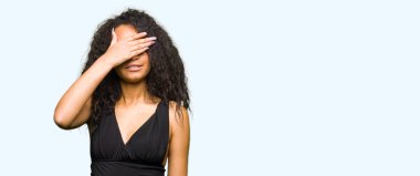 Genç güzel kız moda etek gülümseyen ve gözler için sürpriz kapsayan yüz el ile gülüyor kıvırcık saçlı. Kör kavramı.