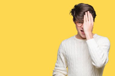 El yüz ve sürpriz duygu kendinden emin gülümseme ile tek gözüyle kapsayan izole arka plan üzerinde gözlük takan genç yakışıklı adam.