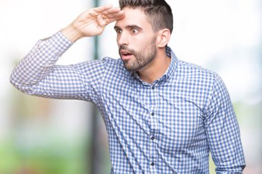 Yakışıklı delikanlı izole arka plan çok mutlu ve gülümseyen uzakta el ile üzerine kafa seyir üzerinde. Arama kavramı.