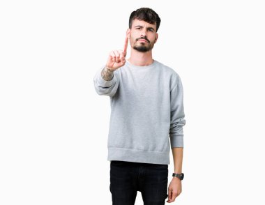 Genç yakışıklı adam giyen kazak izole üzerinde arka plan işaret parmağını ve kızgın ifade ile