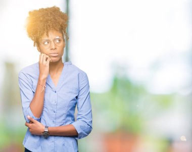 Güzel genç Afro-Amerikan iş kadını elle çene düşünme hakkında soru, dalgın ifade izole arka plan üzerinde. Düşünceli yüzüyle gülümsüyor. Şüphe kavramı.