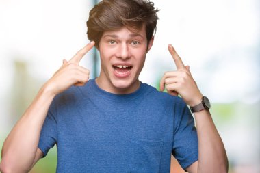 Mavi t-shirt üzerinde izole giyen genç yakışıklı adam arka plan baş hem el parmak, harika bir fikir ya da düşünce, iyi bellek ile işaret eden gülen