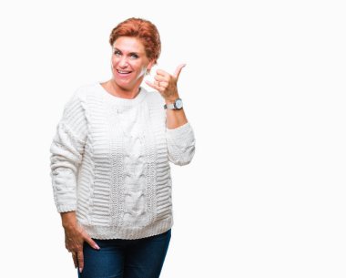 İşin gülümseyen izole arka plan üzerinde kış kazak giyen Atrractive üst düzey beyaz Kızıl saçlı kadın telefon hareketi ile el ve parmak telefonda konuşuyor gibi. Kavramları iletişim.