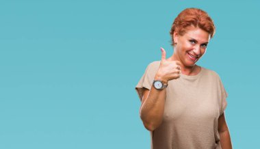 Atrractive üst düzey beyaz Kızıl saçlı kadın hareketi el ile mutlu yaşasın yapıyor izole arka plan yüzünden. Kameraya bakarak başarı gösteren ile ifade onaylama.