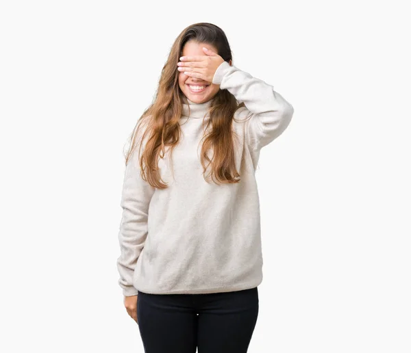 若い美しいブルネット女性は微笑し 笑う顔驚きの目を覆っている手で孤立した背景にタートルネックのセーターを着ています 視覚障害者の概念 — ストック写真