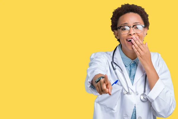 Young african american doctor woman wearing medical coat over isolated background Laughing of you, pointing to the camera with finger hand over mouth, shame expression