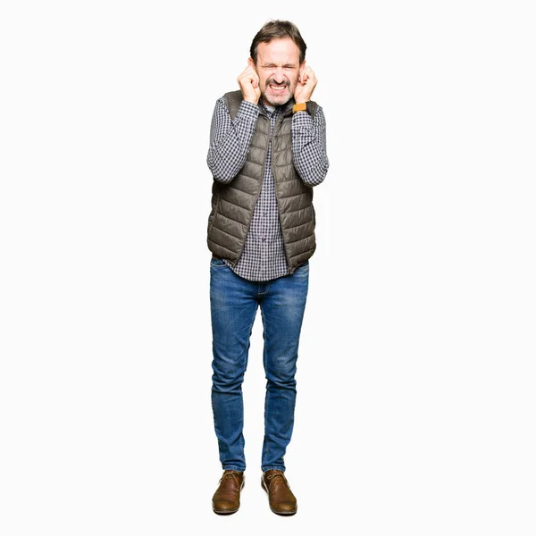 騒々しい音楽のノイズの腹式指で耳を覆う冬ベストを着て中年のハンサムな男性 聴覚障害者の概念 — ストック写真