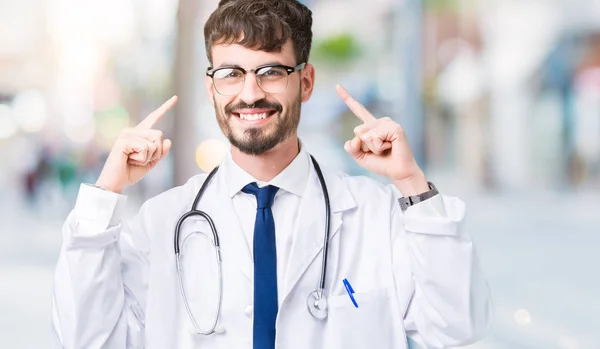 若い医者分離オーバー病院のコートを身に着けている男の背景手指 偉大なアイデアや思考 良いメモリの両方の頭を指している笑みを浮かべて — ストック写真