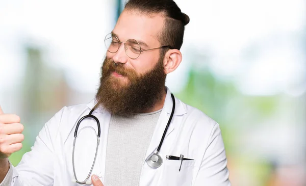 Joven Doctor Rubio Con Barba Vistiendo Abrigo Médico Mirando Orgulloso — Foto de Stock