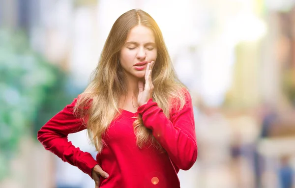 若い美しい金髪女性の歯痛や歯の歯科病気のため痛みを伴う式で手で口に触れて分離の背景に赤いセーターを着ています 歯医者コンセプト — ストック写真