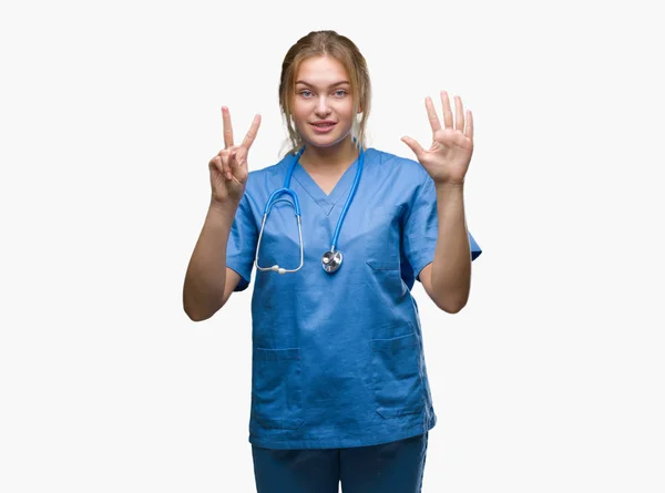 若い白人医師女性の外科医の制服を着て分離を示す背景と指で上向き数は自信を持って 幸せな笑みを浮かべている間 — ストック写真