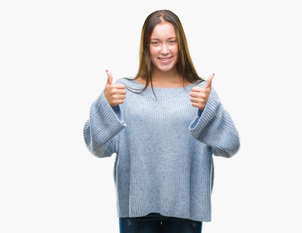 年轻美丽的白人妇女穿着冬季毛衣在孤立的背景成功标志做积极的手势与手 竖起大拇指微笑和快乐 用欢快的表情看着相机 胜利者的手势 — 图库照片