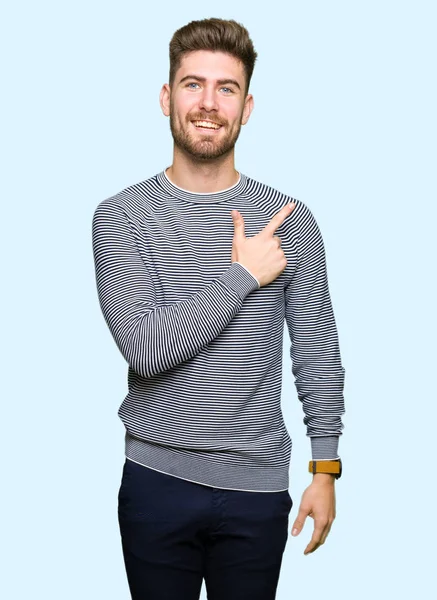 얼굴에 측까지 손가락으로 가리키는 얼굴의 미소와 줄무늬 스웨터를 잘생긴 — 스톡 사진