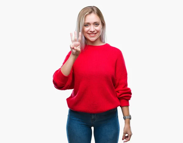 年轻的金发女子穿着冬季毛衣在孤立的背景显示和指向与手指数字三同时微笑自信和快乐 — 图库照片