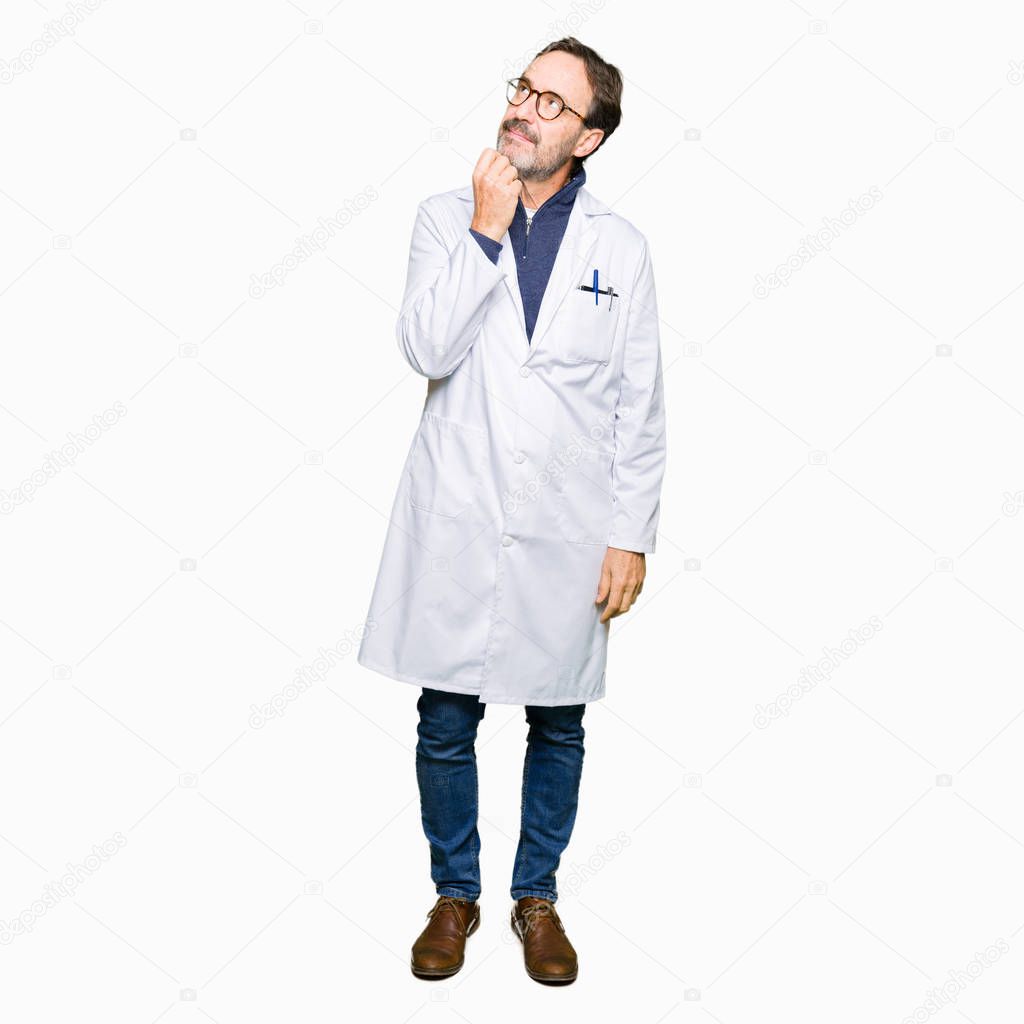Middle age therapist wearing white coat with hand on chin thinking about question, pensive expression. Smiling with thoughtful face. Doubt concept.