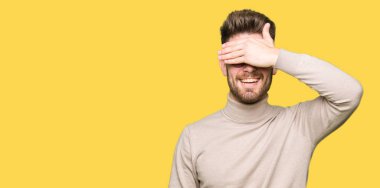 Gülümsüyor ve gözleri için sürpriz kapsayan yüz el ile gülüyor gözlüklü genç yakışıklı iş adamı. Kör kavramı.