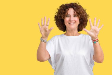 Gösterilen arka plan üzerinde beyaz t-shirt giyen kadın güzel orta ager kıdemli izole ve parmakları ile işaret kendinden emin ve mutlu gülümseyerek süre on numara.