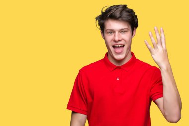 Yakışıklı delikanlı gösterilen ve parmakları ile işaret izole arka plan üzerinde kırmızı t-shirt giyen süre kendinden emin ve mutlu gülümseyerek dört numara.