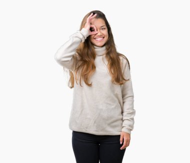 Gülümseyerek el parmakları ile mutlu yüz üzerinden seyir göz ile ok jest yapıyor izole arka plan üzerinde boğazlı kazak giyen genç güzel esmer kadın.