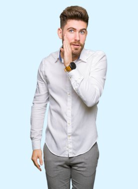 Genç yakışıklı iş adam elini ağzına kötü amaçlı konuşma konuşma fısıldayan gizli söylenti söylüyor