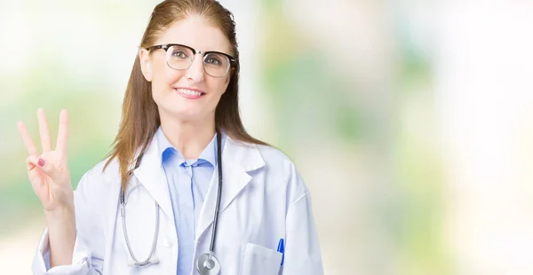 中年成熟的医生妇女穿着医疗外套在孤立的背景显示和手指第三 同时微笑着自信和快乐 — 图库照片
