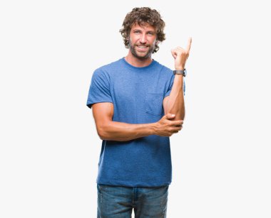 Kameraya bakarak yan el ve parmak ile işaret eden yakışıklı İspanyol modeli adam yüzünde kocaman bir gülümseme ile izole arka plan üzerinde.