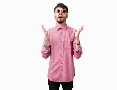 Yakışıklı delikanlı üzerinde güneş gözlüğü takıyor arka plan deli izole ve deli bağırarak ve agresif ifade ve silah kaldırdı bağırıyor. Hayal kırıklığı kavramı.