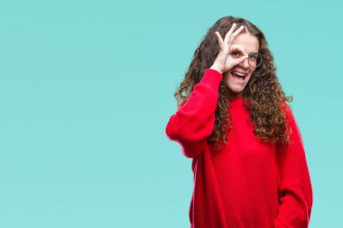 Güzel esmer kıvırcık saçlı genç kız gülümsüyor, parmakları ile mutlu yüz üzerinden seyir göz el ile ok jest yapıyor izole arka plan üzerinde gözlük ve kış kazak giyiyor.