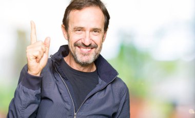 Orta yaş yakışıklı erkek ceket işaret eden bir parmağa başarılı fikirle giyiyor. Çıktıktan ve mutlu. Bir numara.